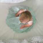 baby sitting on white textile