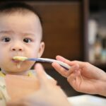 person feeding baby